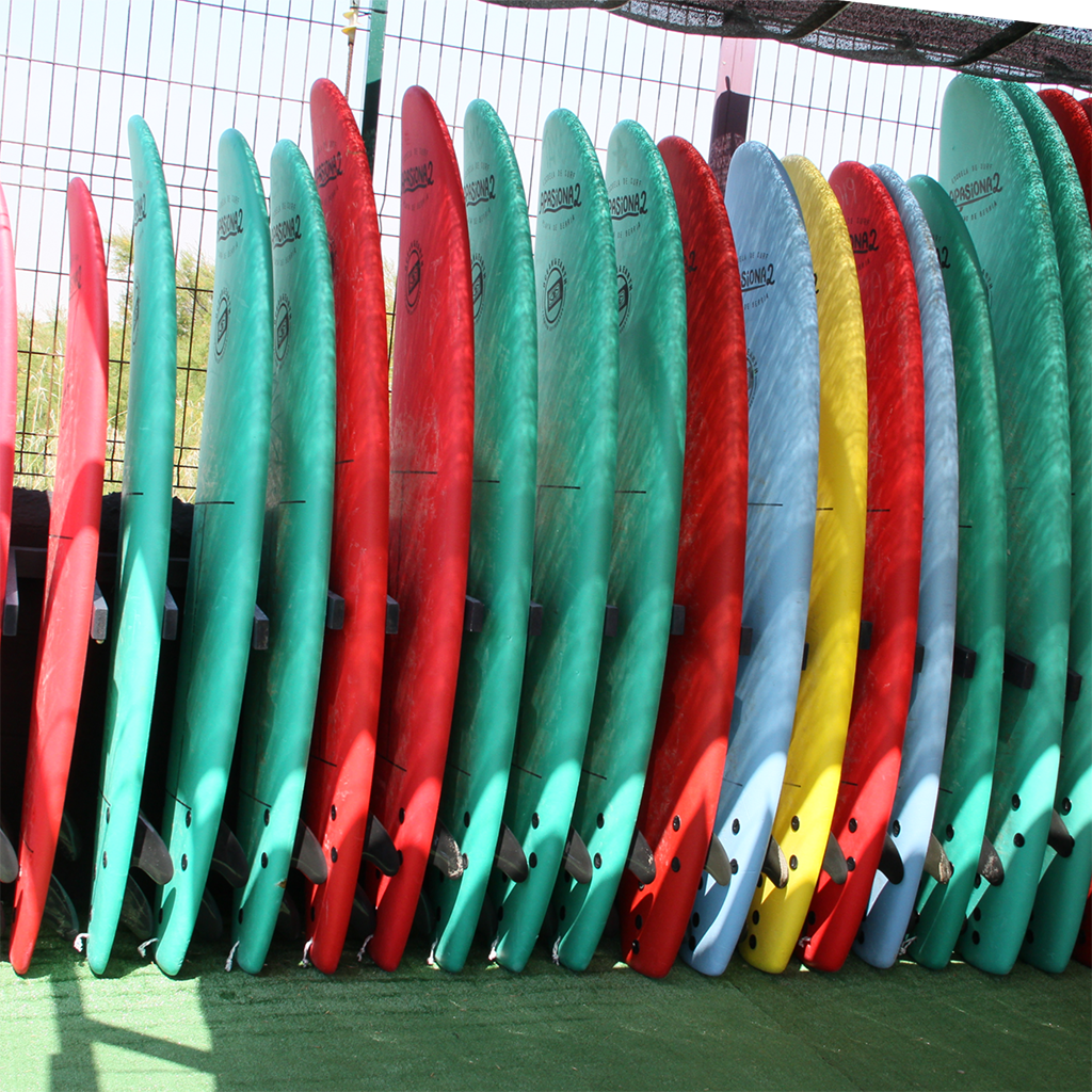 Estudiantes de Escuela Surf Berria remando en el mar, aprendiendo a buscar olas