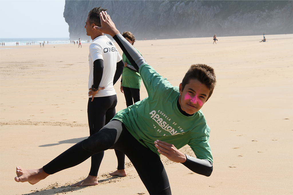Estudiantes de Escuela Surf Berria remando en el mar, aprendiendo a buscar olas