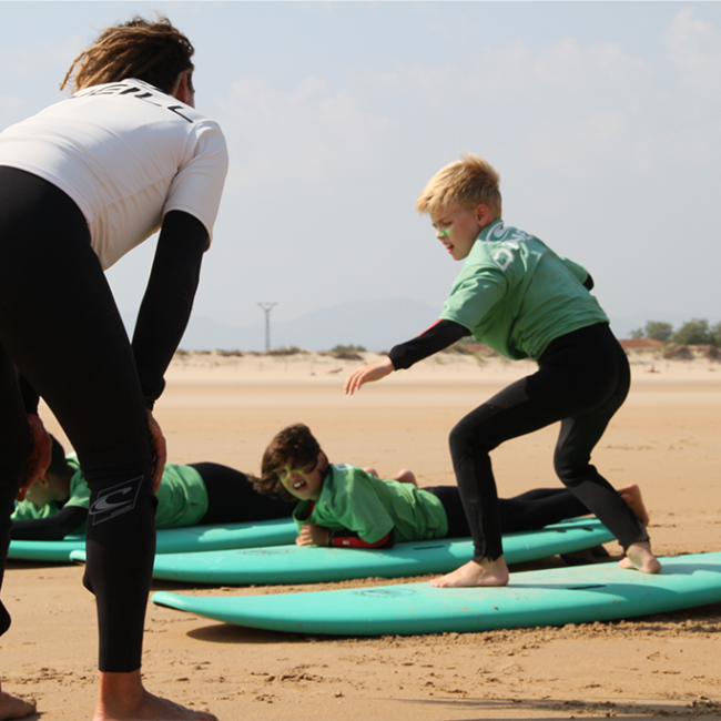 Instructor de Surf enseñando maniobra básica en ola, Playa Berria