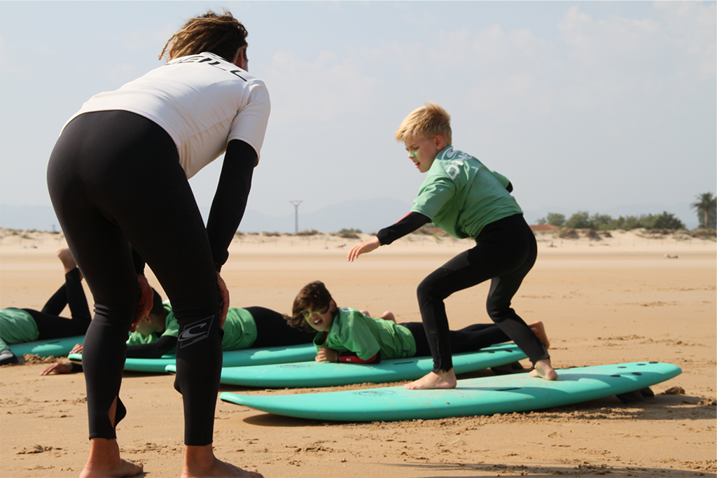 Instructor de Surf enseñando maniobra básica en ola, Playa Berria Instructor de Surf enseñando maniobra básica en ola, Playa Berria